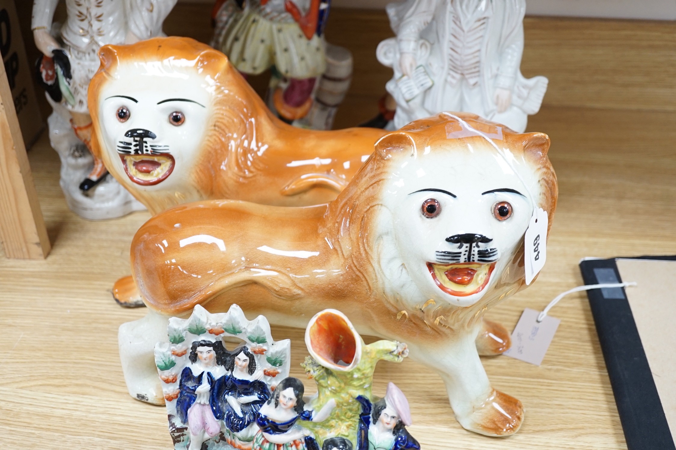 A group of 19th century Staffordshire flat backs and a pair of late Staffordshire pottery lions, 40cms wide